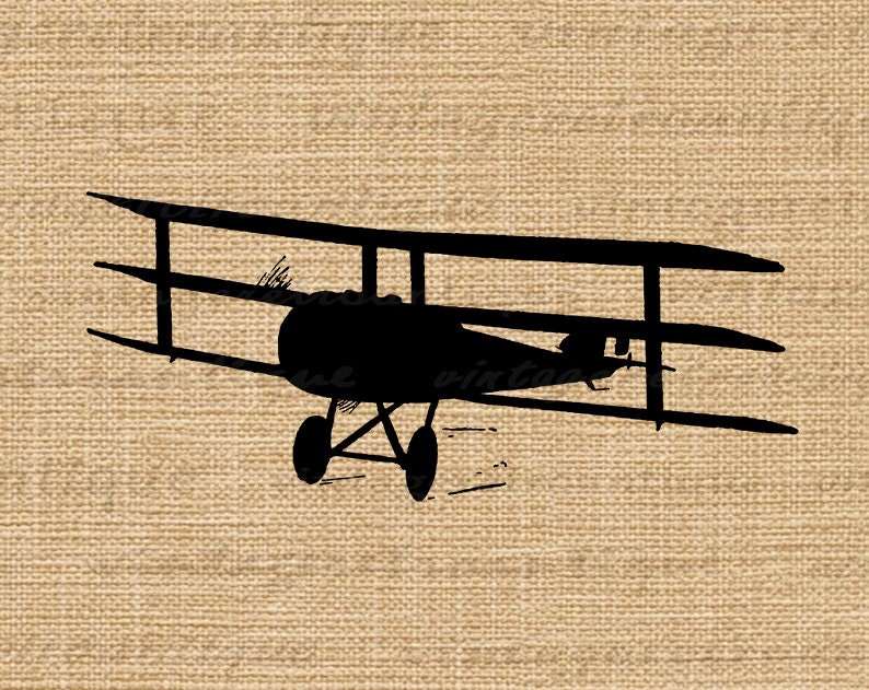 May include: Black silhouette of a vintage biplane aircraft with three wings. The plane is facing forward with the propeller visible. The plane is on a brown hessian background.