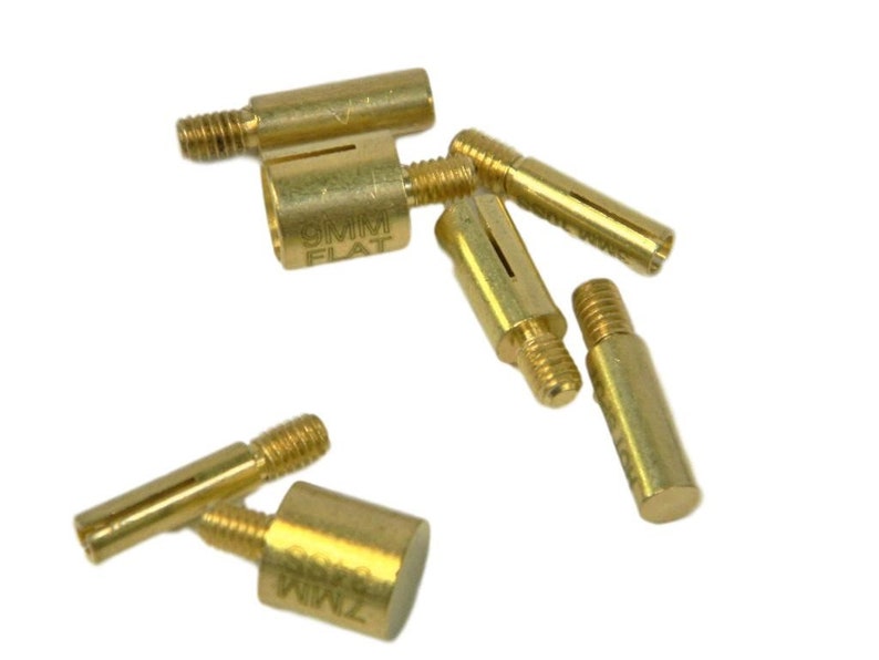 Puede incluir: Un conjunto de componentes de lat&oacute;n para la fabricaci&oacute;n de bol&iacute;grafos, que incluyen insertos roscados y casquillos. Algunas piezas est&aacute;n marcadas con "9MM FLAT" y "7MM ROUND". Los componentes est&aacute;n dise&ntilde;ados para su uso en la elaboraci&oacute;n de bol&iacute;grafos y otros proyectos peque&ntilde;os.