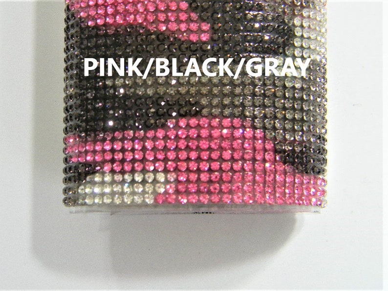 May include: A pink, black, and gray camouflage pattern phone case covered in rhinestones. The text "PINK/BLACK/GRAY" is printed on the case.