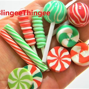 May include: A collection of red and green candy canes, lollipops, and round candies. The candies are decorated with white stripes and swirls.