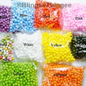 Puede incluir: Una colección de pequeñas bolas de espuma de colores en bolsas de plástico transparente. Los colores incluyen morado, azul, rojo, rosa, mixto, blanco, amarillo, negro, verde y naranja. Cada bolsa está etiquetada con su color respectivo. La imagen está bien iluminada.