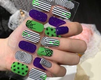 May include: A sheet of Halloween-themed nail art stickers. Designs include black and white spirals, green spiderwebs, black spiders on green, and purple glitter. The sheet has the text "HW-039".