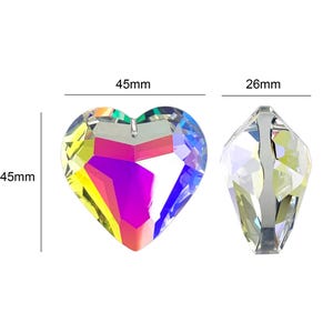 May include: Two crystal prisms, one shaped like a heart and the other a teardrop. The heart prism is 4.5 inches wide and 4.5 inches tall. The teardrop prism is 2.6 inches tall. Both prisms have a rainbow iridescent finish.