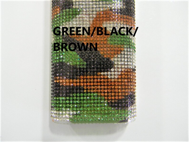 May include: A close-up of a green, black, and brown camouflage pattern made of rhinestones. The text "GREEN/BLACK/BROWN" is printed on the pattern.