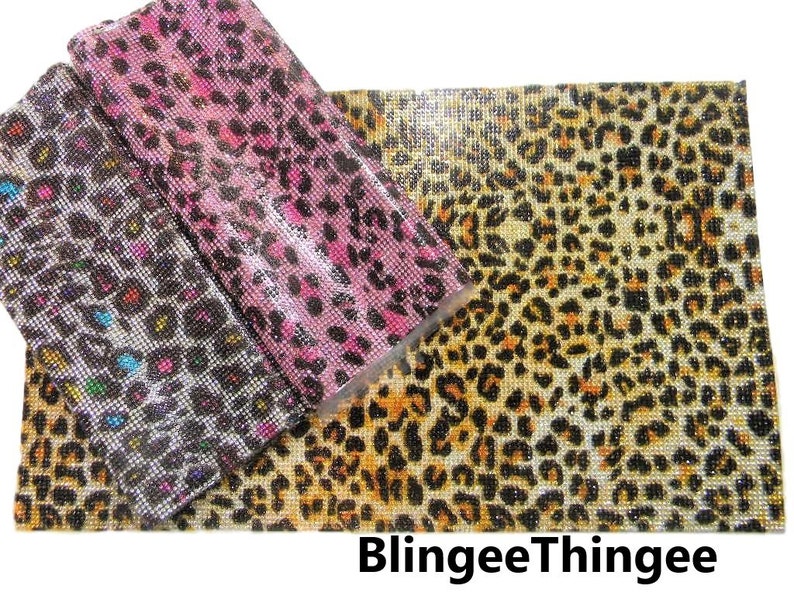 May include: Three sheets of leopard print fabric covered in rhinestones. The fabric is in three colors: black, pink, and brown. The fabric is a popular choice for crafting and DIY projects.