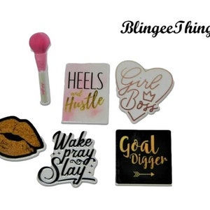 May include: Assortment of six decorative iron-on patches with motivational quotes and designs. The patches feature gold glitter accents and include phrases like "Heels and Hustle", "Girl Boss", "Wake Pray Slay", and "Goal Digger".