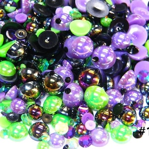 May include: A mix of green, purple, and iridescent round and flat beads. The beads are various sizes and have a shiny finish. #132