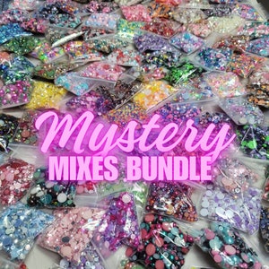 Pode incluir: Uma variedade de enfeites coloridos, brilhantes e iridescentes em pequenos sacos de plástico. Os sacos estão dispostos em uma grande pilha e etiquetados como "Mystery Mixes Bundle".