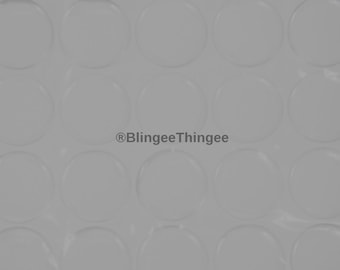 May include: A sheet of clear adhesive dots, arranged in a grid pattern. The dots are designed to be used for crafts, scrapbooking, and other projects.