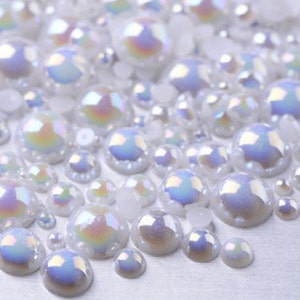 May include: Assortment of iridescent white pearl-like beads in various sizes. The beads have a pearlescent finish and are perfect for crafting and jewelry making.