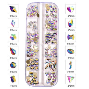 May include: A clear plastic storage box with 12 compartments filled with iridescent rhinestones of various shapes and sizes. The rhinestones are arranged in rows and columns, and each compartment has a different shape and size of rhinestone. The rhinestones are all iridescent, meaning they change color depending on the angle of light.