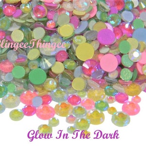May include: Assortment of pastel-colored, iridescent, glow-in-the-dark flatback gems. The gems are in various shapes and sizes, including round, oval, and square.  The gems are perfect for crafting and decorating.