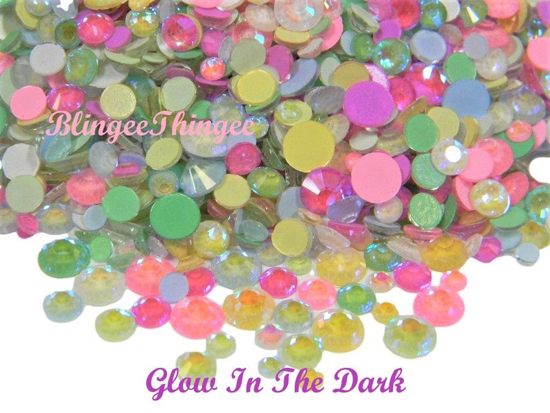 May include: Assortment of pastel-colored, iridescent, glow-in-the-dark flatback gems. The gems are in various shapes and sizes, including round, oval, and square.  The gems are perfect for crafting and decorating.