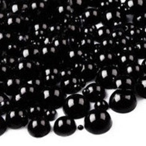 以下が含まれることがあります： 様々なサイズの黒い丸いプラスチックビーズが大量に積み重ねられています