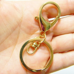May include: Gold-toned metal key chain with a large, round ring and a smaller, swiveling hook.