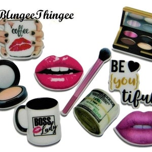 May include: A set of 10 colourful resin cabochons featuring various designs, including coffee mugs, lips, makeup, and money. The cabochons are perfect for crafting projects like jewellery, hair accessories, and keychains.