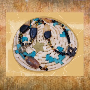 May include: A collection of handcrafted jewelry pieces, including a necklace and earrings, featuring dark, oval-shaped beads with lighter accents. The jewelry is displayed on a woven basket with turquoise and natural tones, and a star-shaped charm.