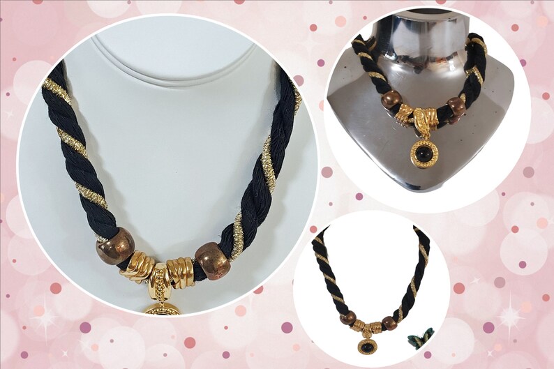 May include: A black and gold rope necklace with gold-toned accents and a circular pendant with a black stone. The necklace features a braided design with gold metallic thread woven into the black rope.