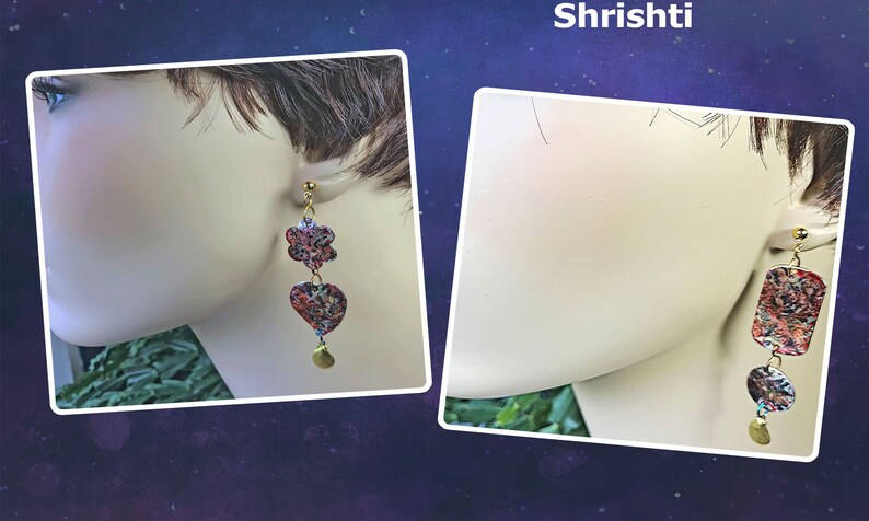 May include: A pair of dangle earrings with a floral and heart-shaped design, and a rectangular and circular design. The earrings are made of a colorful material with red, blue, and gold accents. The earrings are attached to a gold-colored post and have a gold-colored charm at the bottom. The word "Shrishti" is at the top.