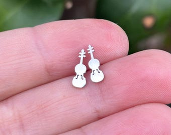 May include: A pair of silver violin-shaped stud earrings. The earrings are small and delicate, and they would make a great gift for a musician or music lover.