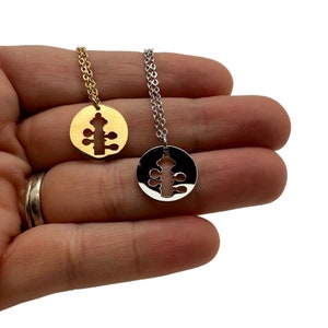 May include: Two necklaces with circular pendants, one gold-toned and one silver-toned. Each pendant features a cut-out design of a stylized fire hydrant. The necklaces are displayed on a white background.