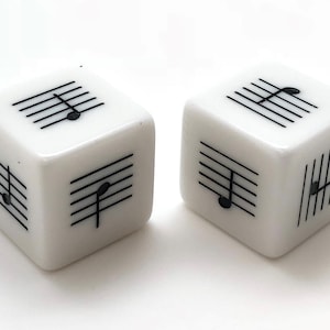 May include: Two white dice with black musical notes and treble clefs printed on each side.