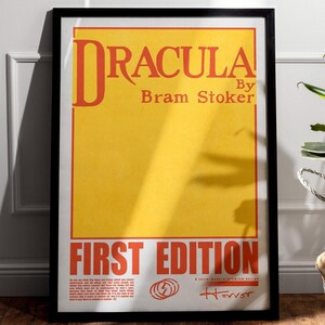 May include: A black framed poster with a yellow background and red text that reads "Dracula by Bram Stoker First Edition" with a lightning bolt symbol and the word "Horror" in red.