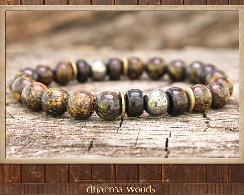 May include: A brown and gold beaded bracelet with a silver bead accent. The bracelet is made of natural materials and has a rustic look.