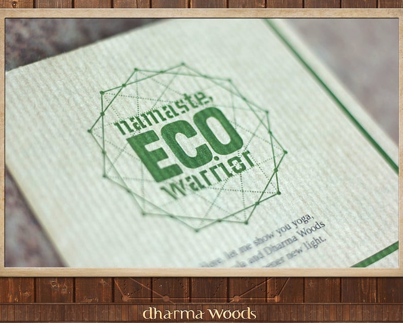 May include: A textured off-white card featuring a green geometric design and the text "namaste, ECO WARRIOR". Below the graphic, smaller text reads "Here, let me show you yoga, Mala and Dharma Woods in a newer new light." The bottom edge displays "dharma Woods".