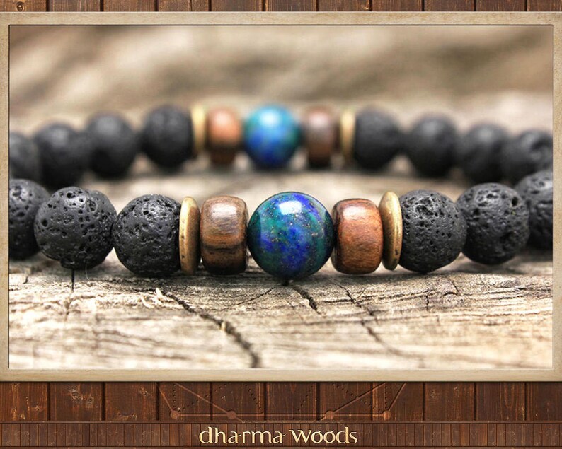 May include: A beaded bracelet featuring a central polished blue and green marbled sphere, flanked by two brown wooden beads and two brass-toned metal spacers, followed by a series of porous black lava stone beads arranged in a circular pattern.
