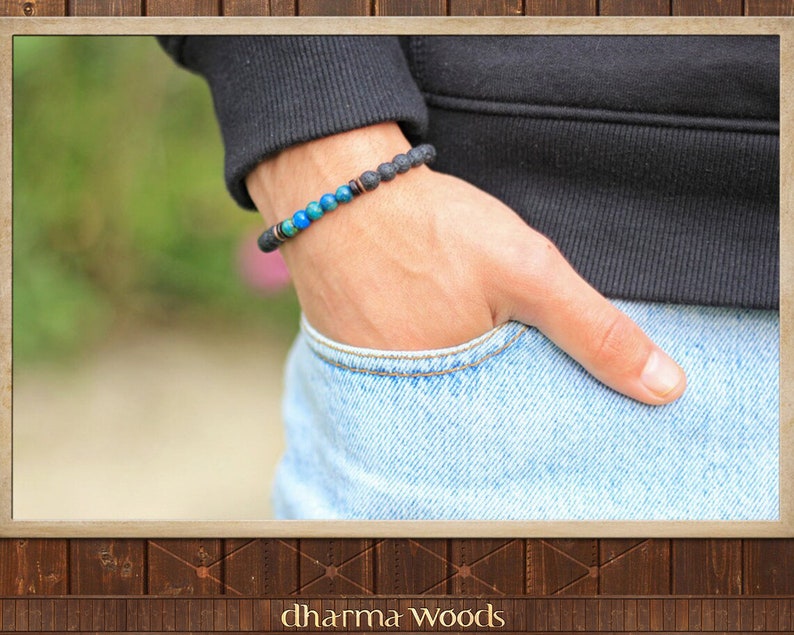 May include: A beaded bracelet featuring a series of textured black lava stone beads, interspersed with a segment of smooth, vibrant blue and turquoise spherical beads, accented by small metallic copper-toned spacers on an elastic cord.