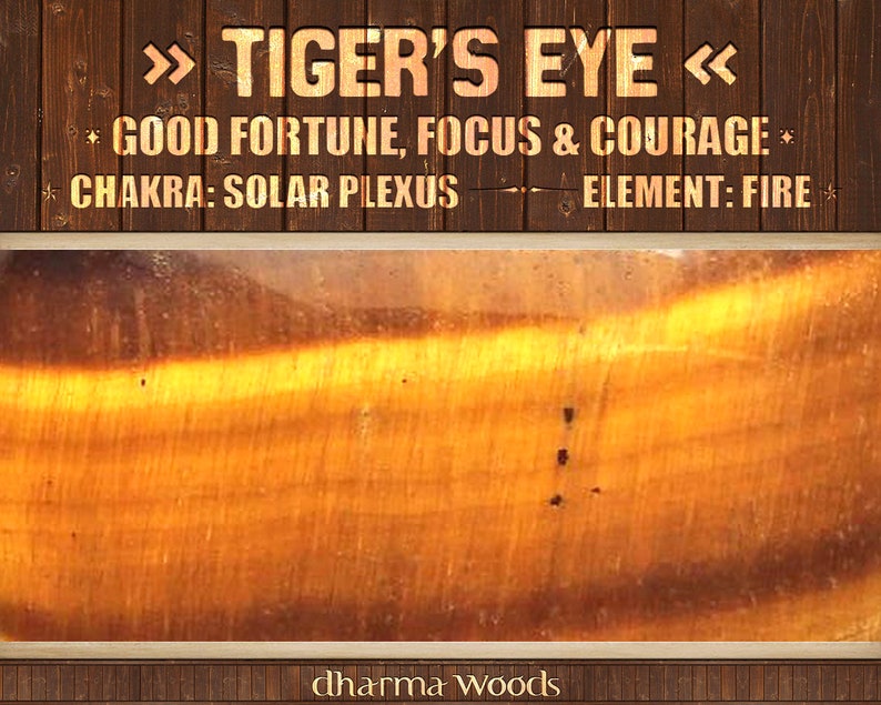May include: A polished Tiger's Eye gemstone with golden-brown bands and chatoyant luster. The text reads: TIGER'S EYE, GOOD FORTUNE, FOCUS & COURAGE, CHAKRA: SOLAR PLEXUS, ELEMENT: FIRE, and dharma WOODS, set against a dark brown wooden background.