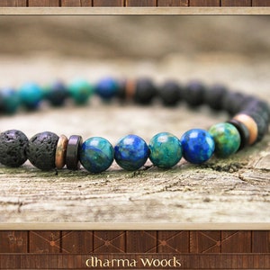 May include: A beaded bracelet featuring a sequence of porous black lava stone beads, smooth blue and green azurite-malachite gemstone beads, and small metallic copper-toned and dark flat spacer beads arranged in a repeating circular pattern.
