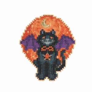 May include: A cross-stitch design featuring a black cat with purple wings, a red star, and a beaded collar. The cat is set against an orange and gold background with a gold crescent moon. The design is on a wooden backing.