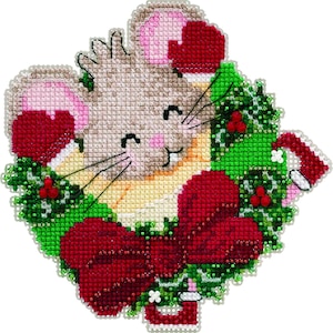 May include: A cross-stitched Christmas ornament featuring a smiling mouse wearing a Santa hat and mittens. The mouse is surrounded by a green wreath with red berries and a large red bow. The ornament is embellished with beads.