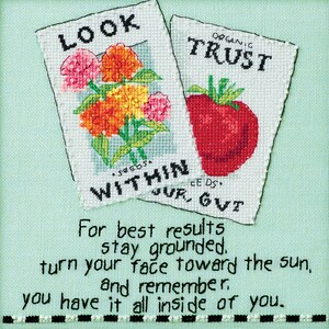 May include: Cross-stitch artwork featuring two seed packet designs. One displays colorful flowers, the other a red strawberry. Text includes "LOOK WITHIN" and "ORGANIC TRUST." Inspirational quote at the bottom.