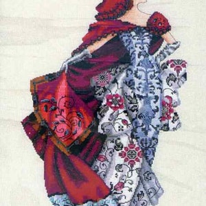 May include: Cross-stitch design of a woman in a long gown and cape. The gown is white with red floral patterns and blue accents. The cape is a deep red with a black and gold border. The woman has red hair.