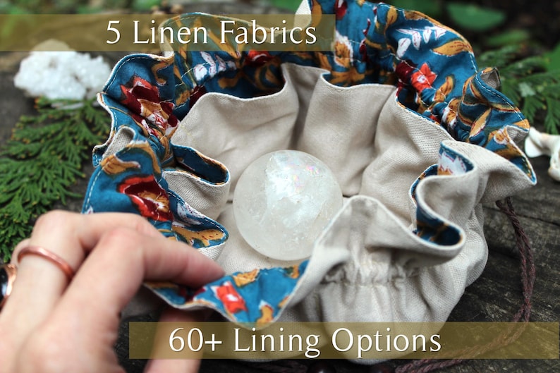 Puede incluir: Una bolsa de lino beige con cord&oacute;n y ribete con estampado floral turquesa, que contiene una bola de cristal transparente. La bolsa tiene el texto "5 Linen Fabrics" y "60+ Lining Options".
