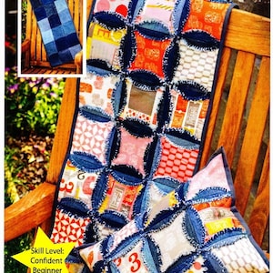 May include: A denim table runner and pillow with a patchwork design. The runner is made from blue denim squares with frayed edges and features a pattern of circles. The pillow is made from the same fabric and has a similar design. The text "Inventive Denim" is visible in the top right corner of the image. The text "Hip Hugger Table Runner & Pillow" is visible at the top of the image. The text "Skill Level: Confident Beginner" is visible in the bottom left corner of the image. The text "A perfect project for old Jeans or Denim by the yard! Precut Friendly - 5" charm squares! ID-1212" is visible at the bottom of the image.