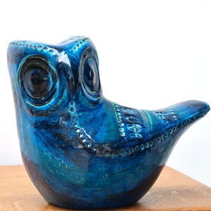 May include: A blue ceramic owl figurine with detailed eyes and a textured surface.