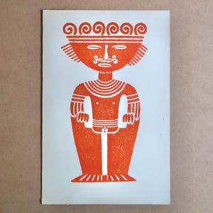 May include: Orange and white print of a stylized figure with a crown, mustache, and patterned details. The figure is depicted in a standing pose with arms at the sides. The artwork is on a light blue background.