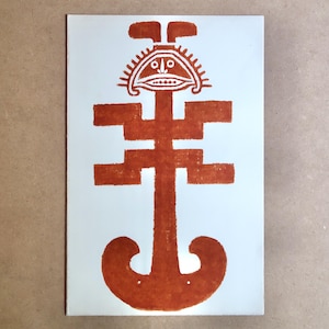 May include: A rectangular print featuring a stylized, symmetrical design in burnt orange against a white background. The design includes a face-like element at the top, a central geometric pattern, and a curved bottom.