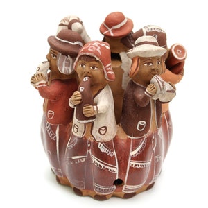 Puede incluir: Un grupo de seis figuras de arcilla marrón de personas tocando instrumentos musicales. Las figuras llevan sombreros y ropa tradicional. Las figuras están dispuestas en círculo y todas miran en la misma dirección.