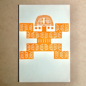May include: An orange linocut print on a white background. The print features a stylized figure with a mask-like face and geometric patterns. The figure is centered on the page, with a simple, symmetrical design.