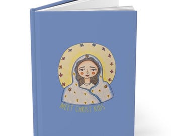May include: A blue journal with a drawing of a woman with a halo and the text "MEET CHRIST KIDS". The illustration features a woman with brown hair and a white veil. The journal is open, revealing white pages.