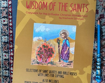 May include: A gold-colored book titled "Wisdom of the Saints" with a colorful illustration of a saint holding a staff and a sheep. The book is for Orthodox Christian homeschool and includes selections of saint quotes and bible verses with lines for copying, prayer templates, and original illustrations of icons for coloring.
