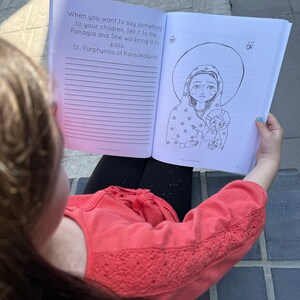 May include: A black and white illustration of a woman holding a child. The image is from a children's book with the text "When you want to say something to your children, tell it to the Panagia and She will bring it to pass. -St. Porphyrios of Kavsokalyvia"