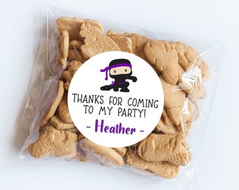 May include: A white circle sticker with a cartoon ninja in black and purple. The sticker says "Thanks for coming to my party! - Heather -"
