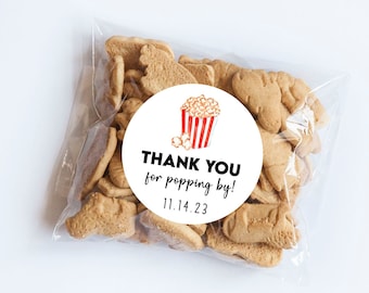May include: A white circle sticker with a red and white popcorn bucket illustration and the text "THANK YOU for popping by! 11.14.23".