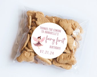 May include: A white circle sticker with a pink fairy illustration and the text "Thanks for coming to Annabelle's fairy first birthday! 07.21.24".